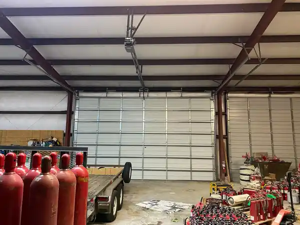Commercial steel building interior with a tall white sectional door