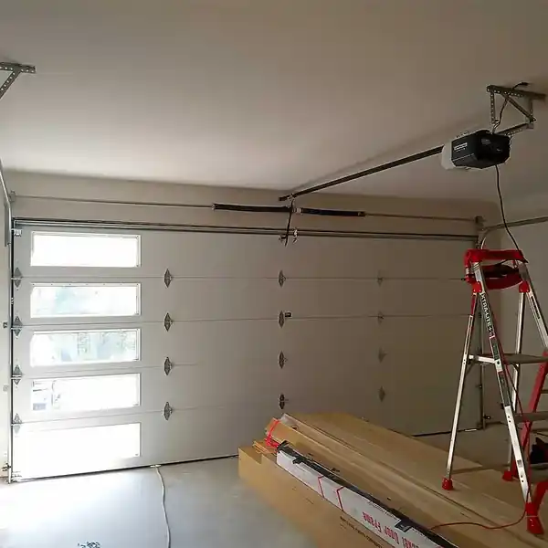 Garage door with vertical windows, a red ladder in front, inside a garage