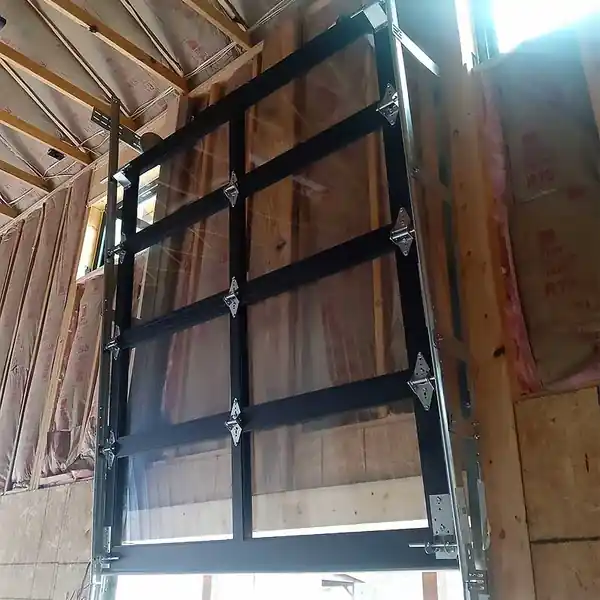 Full-view garage door framed among studs and insulation in new construction