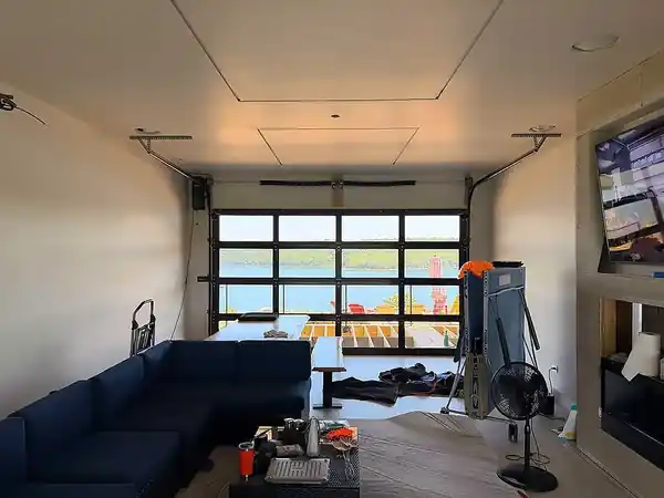 Full-view garage door seen from inside a finished bonus room with a lake visible through the glass