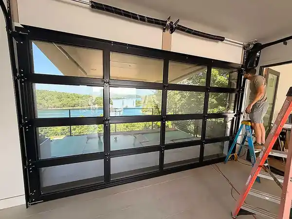Full-view garage door being finished from inside with a lake visible through the glass