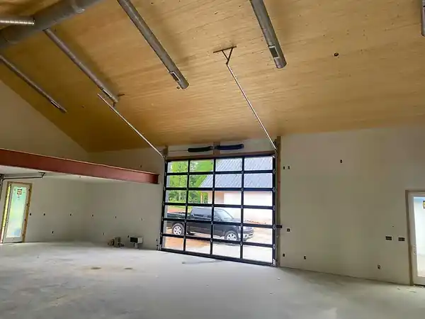 Full-view garage door seen from inside a room with a wood ceiling