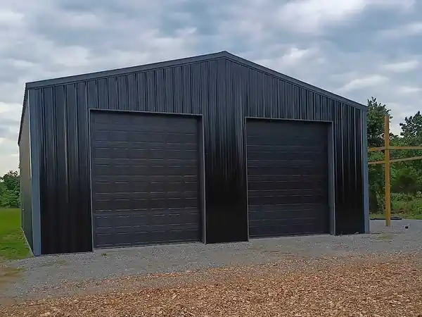 Black steel building with two black ribbed overhead doors