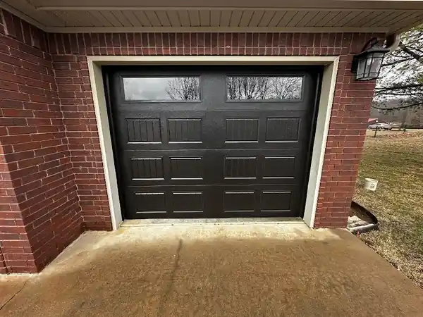 Inside a steel shop building with an open sectional door, one of Elite's commercial installs