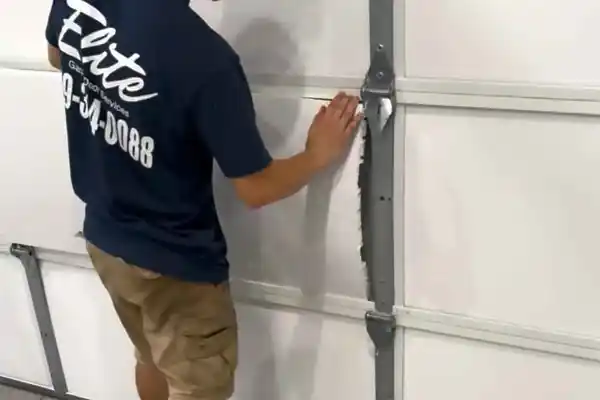 An Elite technician fitting insulation to a sectional garage door panel