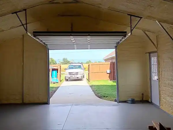 Inside a wood barn looking out through an opened overhead door